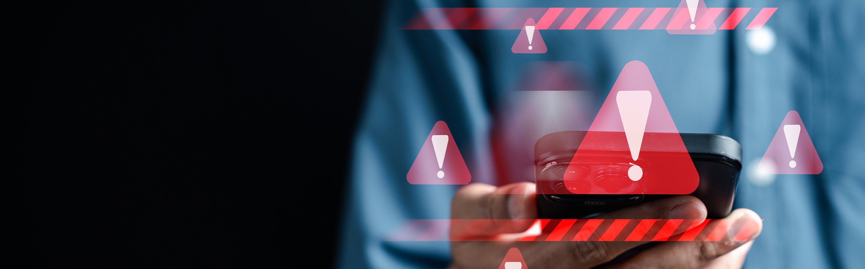 hand holding cell phone with envelope and exclamation points