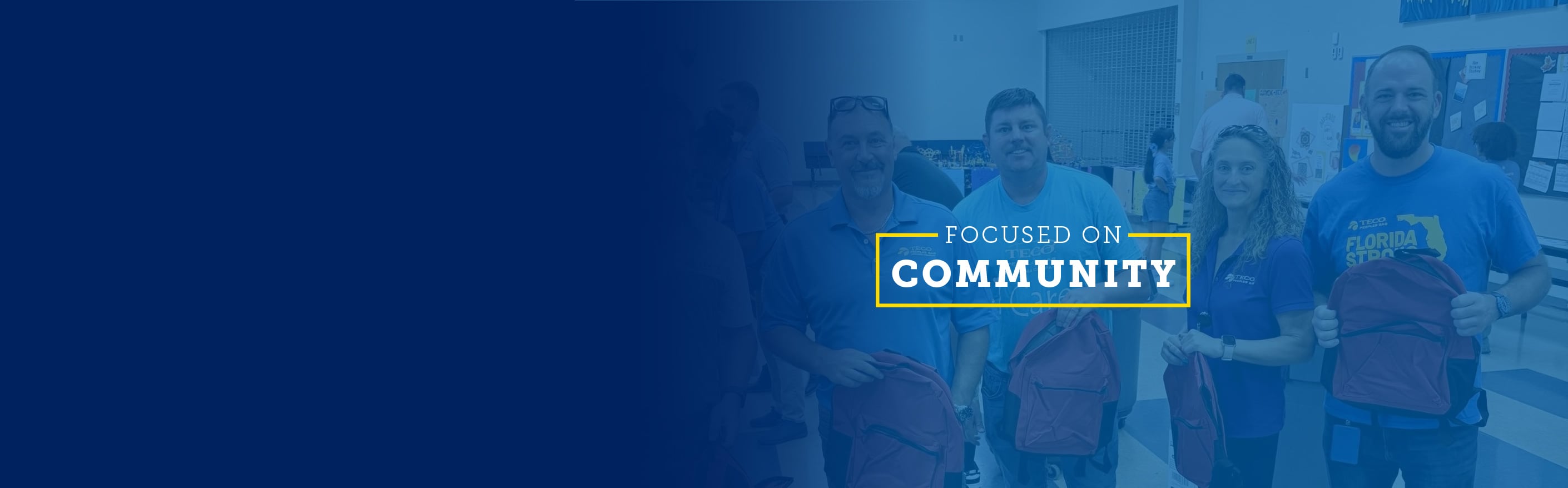 Employees hold red backpacks during a community volunteer event. Overlay text reads: “Focused on Community 2025.”
